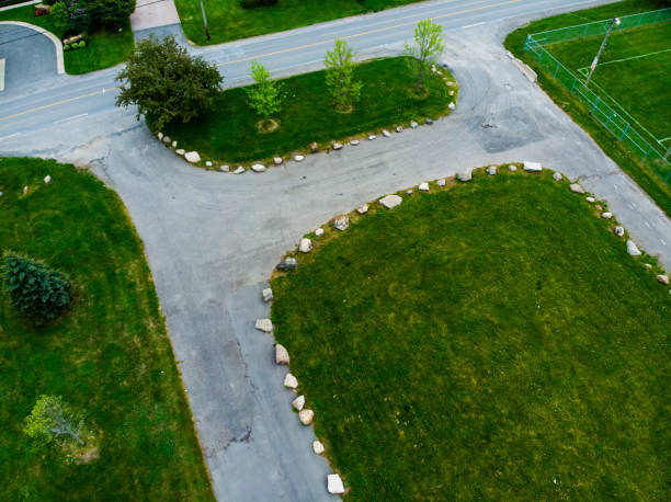 Aerial view of a driveway and surrounding greenery with trees and rocks.