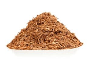 Pile of red cypress mulch isolated on white.